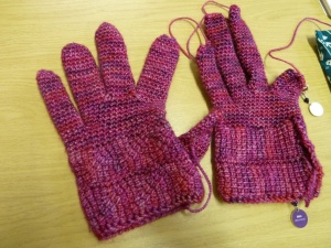 a pair of gloves, the left one missing a thumb and half a finger