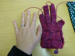 a half-finished glove next to my hand for comparison